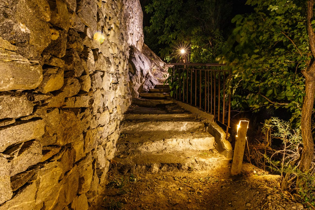 Lit garden pathway at night within the property